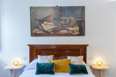 a bedroom with a bed with a painting on the wall at TimeRoma Suites in Rome