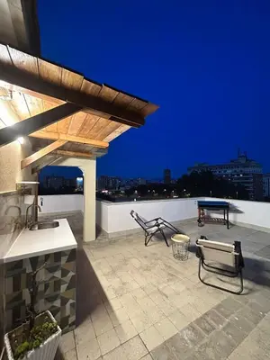 a patio with two chairs and a table on a roof at La Terrazza di Attila in Rome