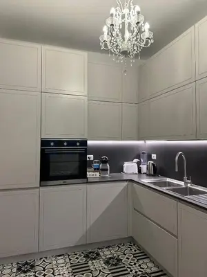 a kitchen with white cabinets and a chandelier at Comodo appartamento a pochi passi dalla fermata Porta Metronia Metro C in Rome