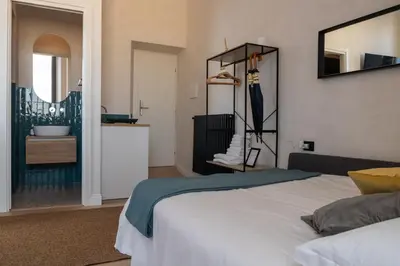 a bedroom with a bed and a bathroom with a sink at Cunabu Apartments in Rome