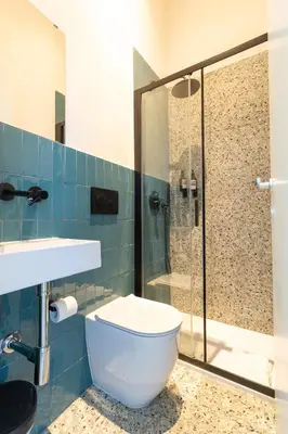 a bathroom with a toilet and a glass shower at Cunabu Apartments in Rome