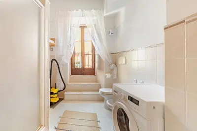 a white bathroom with a washing machine in it at BQA San Crisogono Apartments Rome-Trastevere in Rome