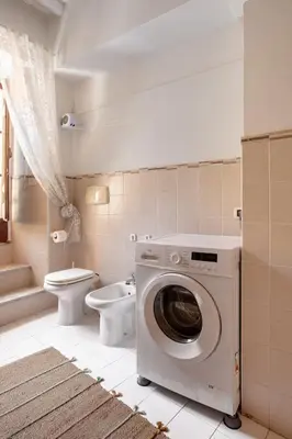 a bathroom with a washing machine and a toilet at BQA San Crisogono Apartments Rome-Trastevere in Rome