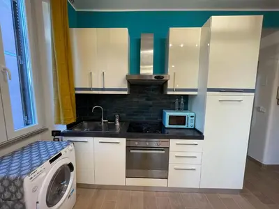 a kitchen with white cabinets and a microwave at Zangàl al Vaticano - Metro Cornelia in Rome