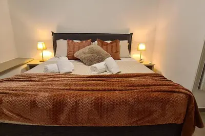 a bedroom with a large bed with two lamps at MON CHERI COLOSSEO in Rome