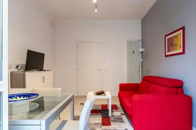 a living room with a red couch and a glass table at GuestHost - Monteverde Quattro Venti Apartment in Rome