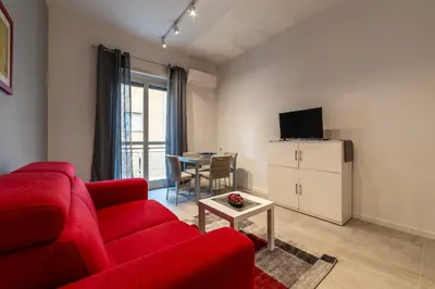 a living room with a red couch and a table at GuestHost - Monteverde Quattro Venti Apartment in Rome