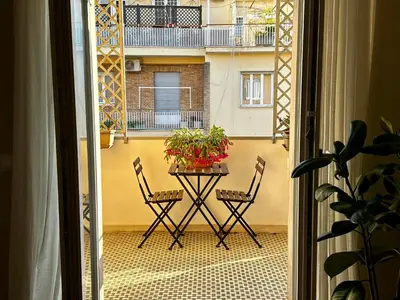 a table and two chairs on a balcony with a building at Giulia’s Corner in Rome