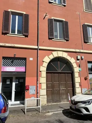 a building with a door and a car parked in front at Guest Art Trastevere Station with AC in Rome