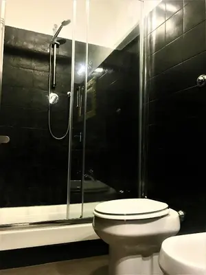 a bathroom with a toilet and a glass shower at Guest Art Trastevere Station with AC in Rome