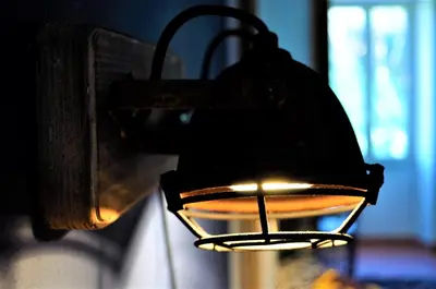 a black lantern hanging on a wall with a light at Guest Art Trastevere Station with AC in Rome