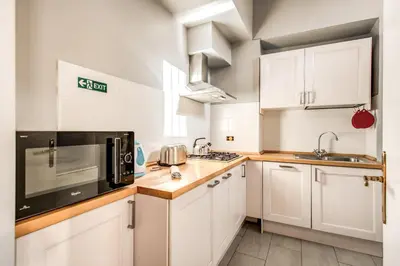 a kitchen with white cabinets and a black microwave at Borgo Pio Passetto Papale in Rome
