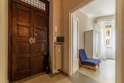 a room with a door and a blue chair at GuestHost - Piazza Bainsizza Elegant Apartment in Rome