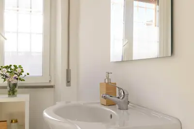 a white sink in a bathroom with a mirror at San Giovanni Home in Rome