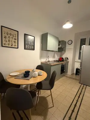 a kitchen with a wooden table and chairs in a kitchen at Pietra Apartment,Colosseo in Rome