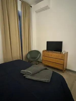 a bedroom with a bed and a tv and a chair at Pietra Apartment,Colosseo in Rome
