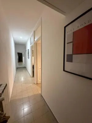 a hallway with a painting on the wall and a tile floor at Pietra Apartment,Colosseo in Rome