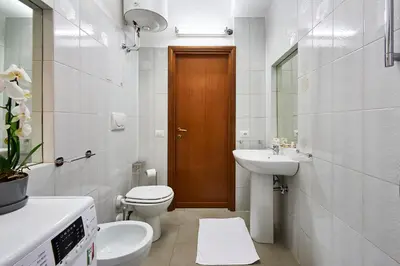 a white bathroom with a toilet and a sink at Anastasio II apartment in Rome