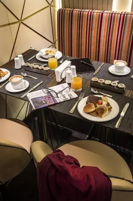 a table with a plate of food and orange juice at Palazzo Navona Hotel in Rome
