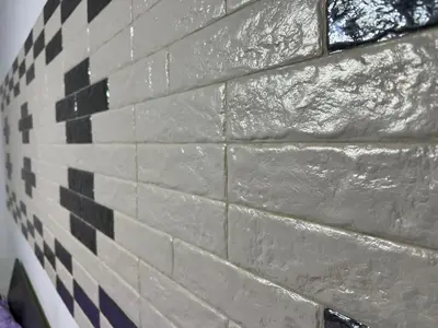 a brick wall with black and white tiles on it at Candia House in Rome