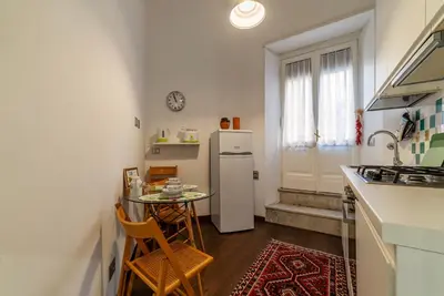 a living room with a blue couch and green walls at GuestHost - Piazza di Roma Turquoise Apartment in Rome