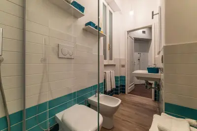 a green bedroom with a bed and a mirror at GuestHost - Piazza di Roma Turquoise Apartment in Rome
