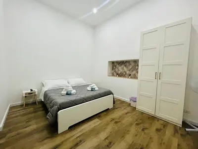 a white bedroom with a bed and a closet at Boiardo Art House in Rome
