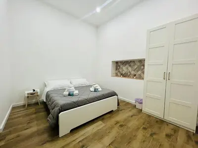 a white bedroom with a bed and a closet at Boiardo Art House in Rome