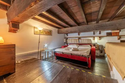 a bedroom with a bed in a room with wooden ceilings at Historical Loft at Campo de Fiori in Rome