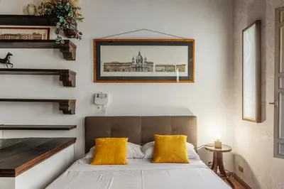 a bedroom with a bed with two yellow pillows at Historical Loft at Campo de Fiori in Rome