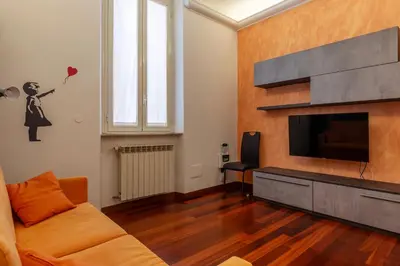 a living room with a couch and a television at GuestHost - Termini Live Laugh & Love Apartment in Rome