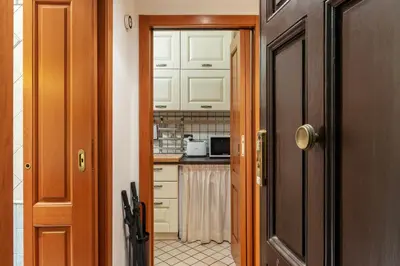 a kitchen with white cabinets and a counter top at GuestHost - Termini Live Laugh & Love Apartment in Rome