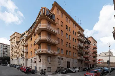 a tall orange building with cars parked in front of it at GuestHost - Casa Mariu' a San Pietro in Rome