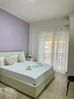 a white bedroom with a large bed and a window at The Roman Guesthouse in Rome