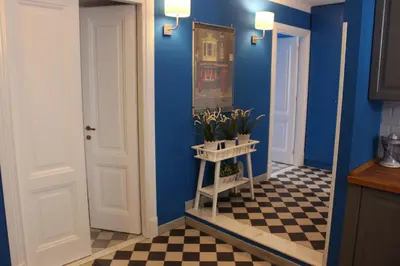 a hallway with blue walls and a checkered floor at Le Stanze di Pietro in Rome