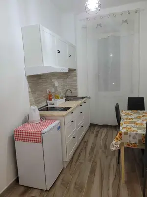 a kitchen with white cabinets and a sink and a table at in the garden in Rome