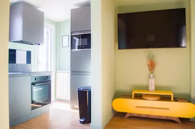 a kitchen with a yellow table and a tv on the wall at Navona Penthouse - Attico Vista Cupola 4 posti in Rome