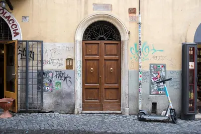 a scooter parked in front of a building with a door at Cinque Loft in Rome