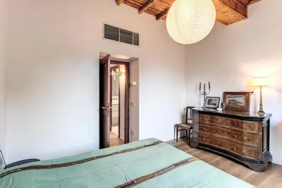 a bedroom with a bed and a wooden dresser at Trastevere Outstanding 4 BR Terraced Apartment in Rome
