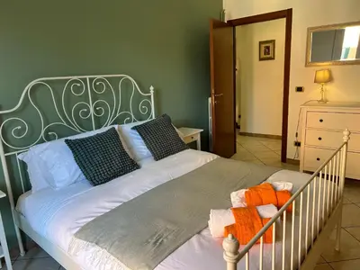 a bedroom with a white bed with a metal headboard at Casa dei fiori by GHOR in Rome