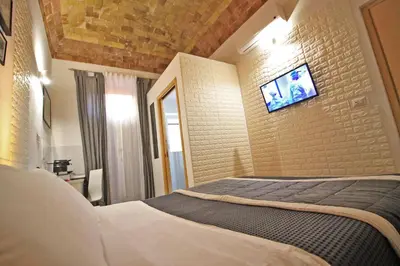a bedroom with a bed and a tv on a brick wall at Machiavelli Suites in Rome