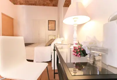 a room with a table with a lamp and a bed at Machiavelli Suites in Rome