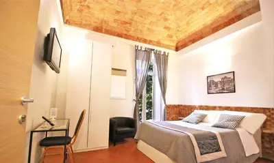 a bedroom with a bed and a table and a window at Machiavelli Suites in Rome