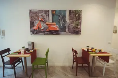 a room with two tables and a scooter on the wall at Vantaggio Suites in Rome
