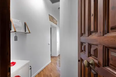 a hallway with a wooden door and a white wall at LPR Pantheon - Stylish Apartment at the Pantheon in Rome
