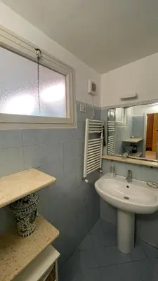 a white bathroom with a sink and a window at Centro storico appartamento con terrazza in Rome