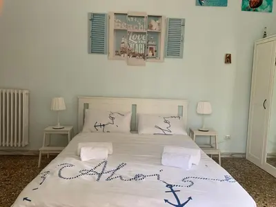 a bedroom with a large white bed with two lamps at Home Carpiceci in Rome