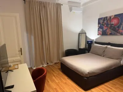 a bedroom with a bed and a desk and a television at Be Your Home - Mazzini 144 in Rome