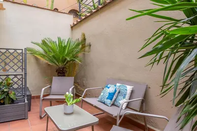 two chairs and a table on a patio with plants at iFlat Wonderful Home in Monti in Rome