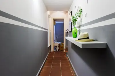 a hallway with gray walls and a white shelf with a green vase at iFlat Wonderful Home in Monti in Rome